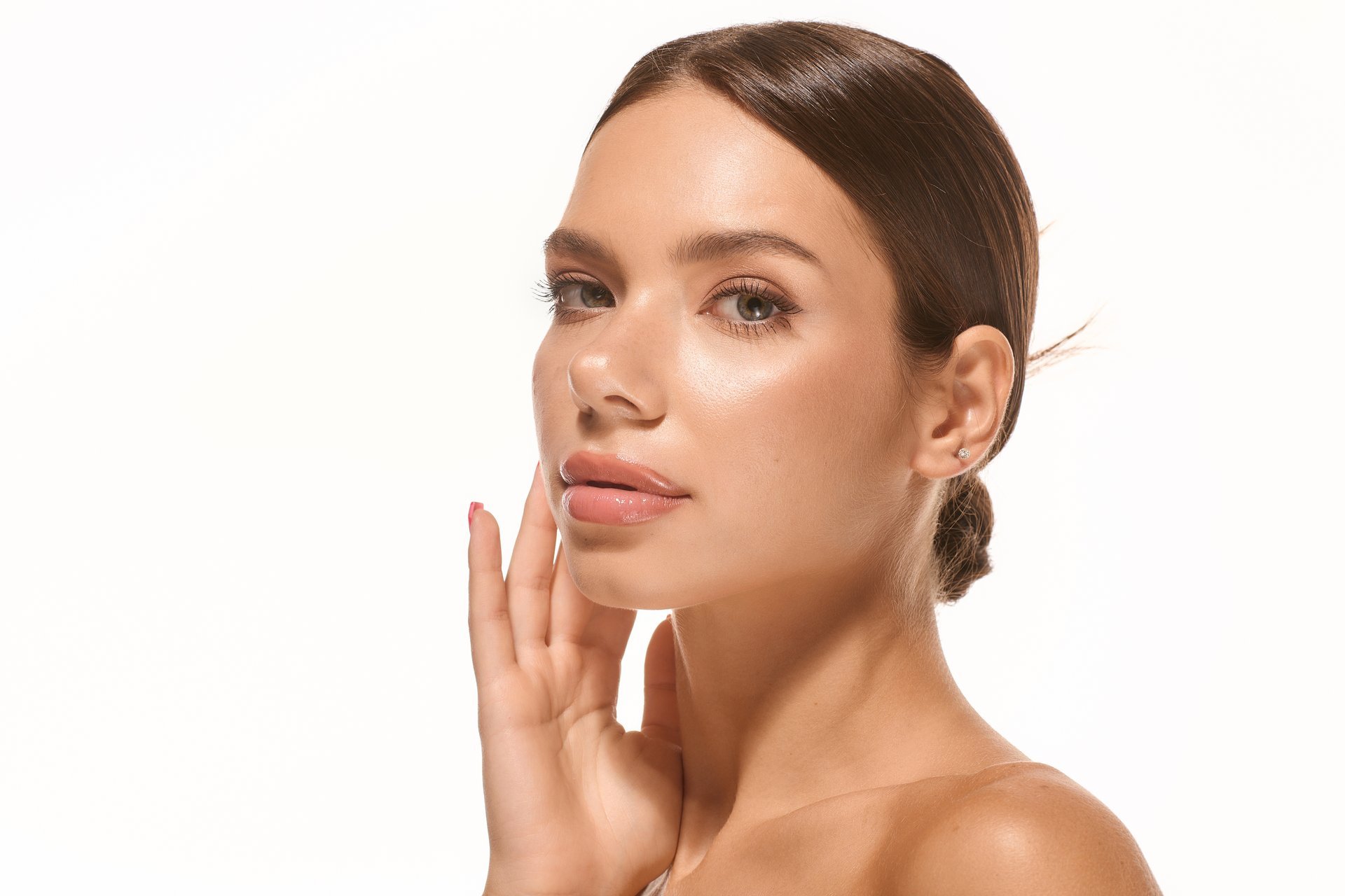 Young woman with radiant glowing skin in soft dramatic lighting